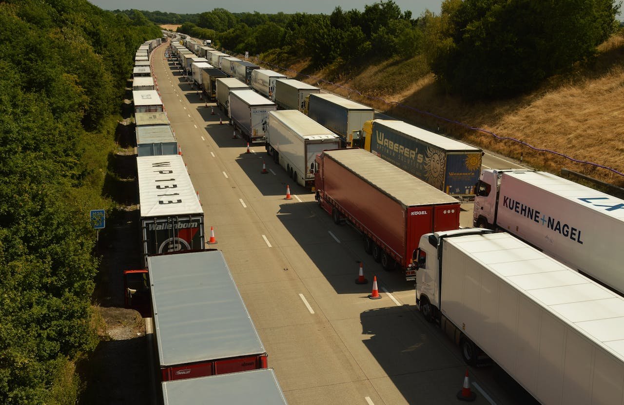 Drone shot capturing traffic jam of trailer trucks on a highway in England.