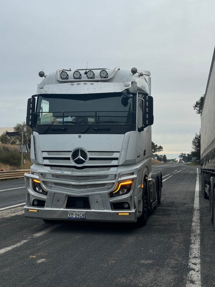 pexels-photo-28264506 A sleek white truck travels along a highway, showcasing modern transportation.