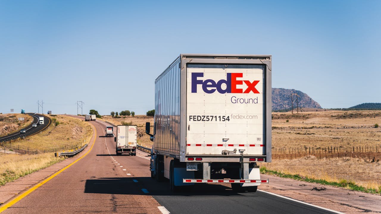 FedEx truck on a scenic desert highway in Arizona, showcasing transportation and logistics.